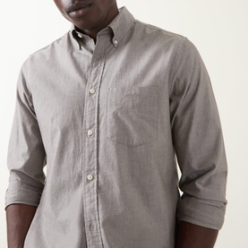 Model wearing Gant Brown Melange Reg Shirt in cotton, featuring button-down collar, chest pocket, and rolled sleeves.