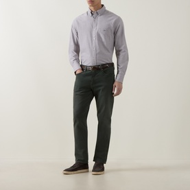 Model wearing Gant Shield Logo Oxford Shirt in Faded Taupe with button-down collar, styled with dark green trousers and brown loafers.