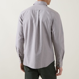Model wearing Gant Shield Logo Oxford Shirt in Faded Taupe, rear view showing box pleat and long sleeves, styled with green trousers.
