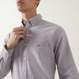 Model wearing Gant Shield Logo Oxford Shirt in Faded Taupe, button-down collar, chest pocket with shield logo, adjusting collar
