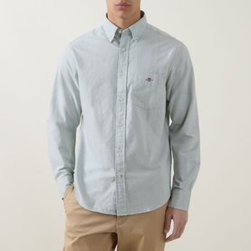 Model wearing Gant Shield Logo Oxford Shirt in Surplus Mint with button-down collar and chest pocket, styled with tan chinos.