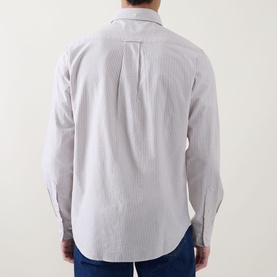 Model wearing Gant light taupe cotton regular fit shirt, rear view showing box pleat detail, styled with blue jeans.