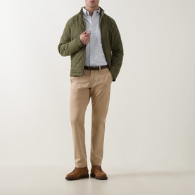 Model wearing Gant Shield Logo Striped Shirt in Surplus Mint, styled with olive quilted jacket, beige chinos and brown suede shoes.