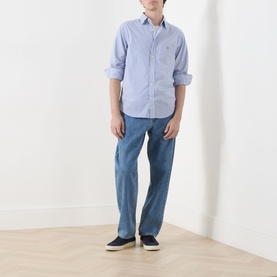 Model wearing Gant Classic Stripe Banker Shirt in College Blue with button-down collar and chest pocket, styled with light blue jeans and navy shoes.