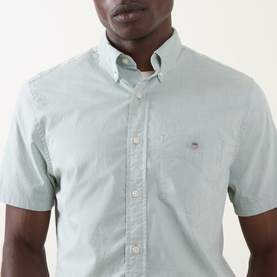 Model wearing Gant Shield Logo Shirt in Surplus Mint, short sleeves, button-down collar, and embroidered shield logo on chest pocket.