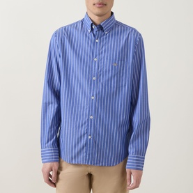 Model wearing Gant Shield Logo Striped Casual Shirt in College Blue with white stripes, long sleeves, button-down collar, styled with beige trousers.