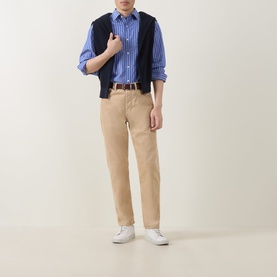 Model wearing Gant Shield Logo Striped Casual Shirt in College Blue, styled with navy knit vest, tan chinos and white trainers.