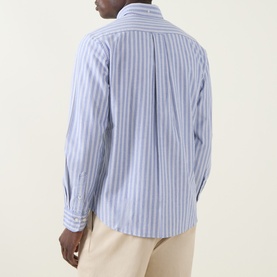 Model wearing Gant Shield Logo Striped Shirt in College Blue, back view, long sleeves, with cream trousers.