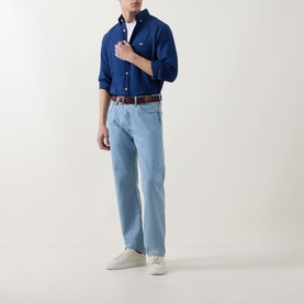 Model wearing Gant Dark Indigo Reg Shirt in cotton, styled with light wash jeans, brown belt and white trainers.