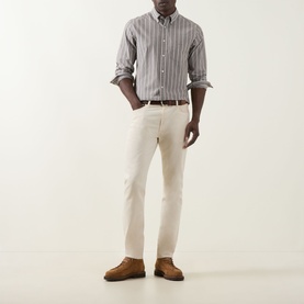 Model wearing Gant Logo Striped Shirt in brown melange with button-down collar, styled with cream trousers and tan suede shoes.