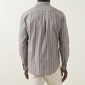 Model wearing Gant Logo Striped Shirt in brown melange, back view showing striped pattern, long sleeves and button cuffs, styled with cream trousers.