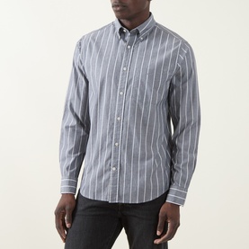 Model wearing Gant Logo Striped Shirt in dark indigo melange, button-down collar, long sleeves, chest pocket, styled with dark jeans.