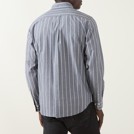 Model wearing Gant Logo Striped Shirt in dark indigo melange, rear view showing vertical white stripes, long sleeves, styled with dark jeans.