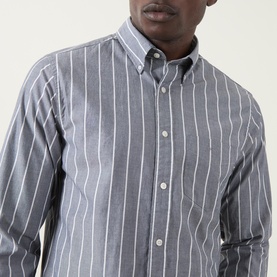 Model wearing Gant Logo Striped Shirt in Dark Indigo Melange, featuring button-down collar, white stripes, and long sleeves.