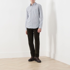 Model wearing Gant Classic Check Logo Shirt in Faded Taupe with button-down collar and check pattern, styled with dark trousers and brown boots.