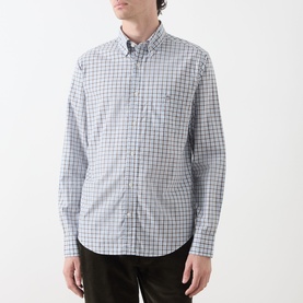Model wearing Gant Classic Check Logo Shirt in Faded Taupe, button-down collar, long sleeves, chest pocket, check pattern, with dark trousers.