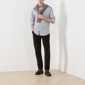 Model wearing Gant Classic Check Logo Shirt in Faded Taupe, button-down collar, long sleeves, styled with dark trousers and brown loafers.