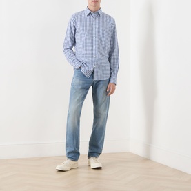 Model wearing Gant Classic Check Logo Shirt in Fresh Blue check, styled with light wash jeans and white trainers.