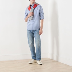 Model wearing Gant Classic Check Logo Shirt in Fresh Blue check with a red scarf, styled with light-wash jeans and white low-top trainers.