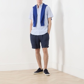 Model wearing Gant Fresh Blue regular fit short-sleeve cotton shirt, styled with navy shorts, blue gilet and navy canvas shoes.