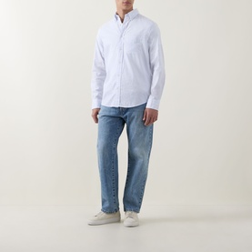 Model wearing Gant light blue cotton regular fit casual shirt, styled with light wash jeans and white trainers