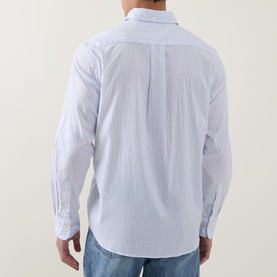 Model wearing Gant Reg Shirt in light blue fine stripe cotton, rear view, styled with blue jeans