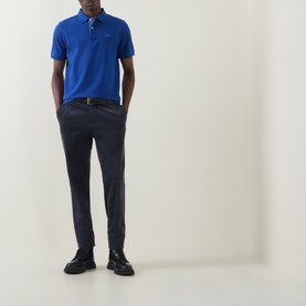 Model wearing Gant Contrast Collar Logo Polo Shirt in Crisp Blue with navy trousers and black shoes.