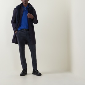 Model wearing Gant Contrast Collar Logo Polo Shirt in Crisp Blue, styled with navy coat, grey trousers and black boots.