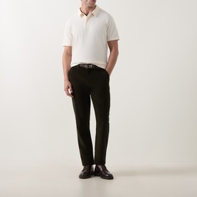 Model wearing Gant Cream Regular Polo with dark green trousers, brown leather belt and dark shoes.