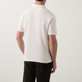 Model wearing Gant Regular Polo in cream, rear view, short sleeves, styled with dark trousers
