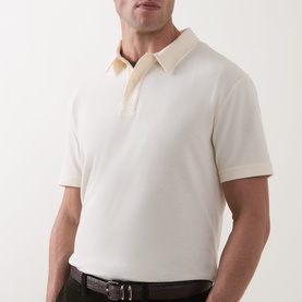Model wearing Gant cream regular polo shirt in 100% cotton, styled with a dark leather belt