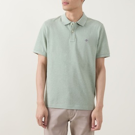 Model wearing Gant Regular Polo in soft green melange, short sleeves, piqu&eacute; texture with logo embroidery, styled with beige trousers.