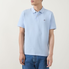 Model wearing Gant Regular Polo in fresh blue, short sleeve pique cotton with logo badge, styled with light wash jeans.
