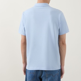 Model wearing Gant Regular Polo in Fresh Blue, rear view, short sleeves, styled with blue jeans.