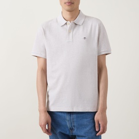 Model wearing Gant Shield Logo Pique Polo Shirt in Glacier Melange, short sleeves, two-button collar, embroidered logo. Styled with blue jeans.