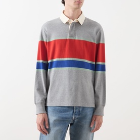 Model wearing Gant Blocked Stripe Rugby Shirt in grey melange with red and blue chest stripes, cream collar, styled with light blue jeans.