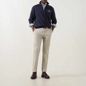 Model wearing Gant Evening Blue half-zip sweatshirt with chest logo, styled with beige chinos, blue shirt and brown loafers.