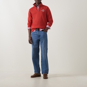 Model wearing Gant Maple Fire half-zip sweatshirt with blue straight-leg jeans, check shirt, and brown suede shoes.