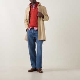 Model wearing Gant Maple Fire sweatshirt styled with beige overcoat, pink check shirt, blue jeans and brown leather shoes.