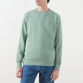 Model wearing Gant Shield Logo Sweatshirt in Surplus Mint, crew neck, ribbed trims, small embroidered logo, styled with blue jeans.