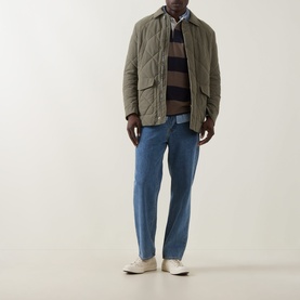 Model wearing Gant Stripe Heavy Rugger Shirt in Faded Taupe, styled with an olive quilted jacket and blue jeans.