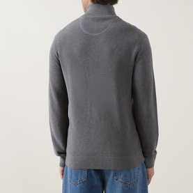 Model wearing Gant Shield Logo Zip Sweater in dark grey melange, back view, showing textured knit and zip collar. Styled with blue jeans.