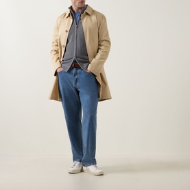 Model wearing Gant Shield Logo Zip Sweater in dark grey melange, styled with a beige trench coat, blue jeans, and white trainers.