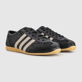 Adidas trainers in utility black with cream white three-stripe detail, textured upper, lace-up fastening, and gum rubber sole.