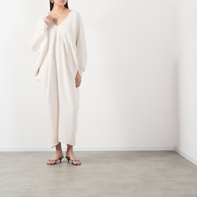 Model wearing The Frankie Shop ivory viscose dress with V-neck and draped batwing sleeves, styled with strappy heeled sandals.