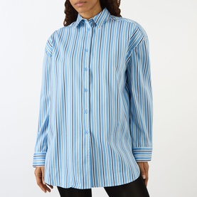 Model wearing The Frankie Shop Oana Padded Stripe Shirt in Blue Multi Stripe with pointed collar, padded dropped shoulders and long sleeves.