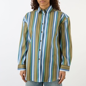 Model wearing The Frankie Shop Oana Padded Stripe Shirt in Green Multi Stripe, with pointed collar, button fastening and long sleeves