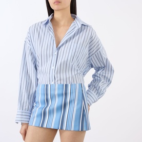 Model wearing The Frankie Shop Blue Multi Stripe skirt, styled with a matching striped cropped shirt in light blue and white.