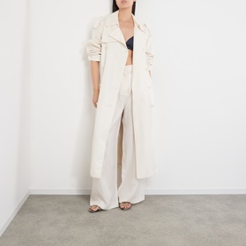Model wearing The Frankie Shop ivory silk wide-leg trousers, styled with matching longline coat and black bralet.
