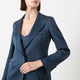 Model wearing a tailored navy blue blazer with peaked lapels and welt pockets, styled over a matching navy camisole